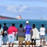 Anxious Mauritians use their hair and stockings to mop up leaking oil from a stranded ship